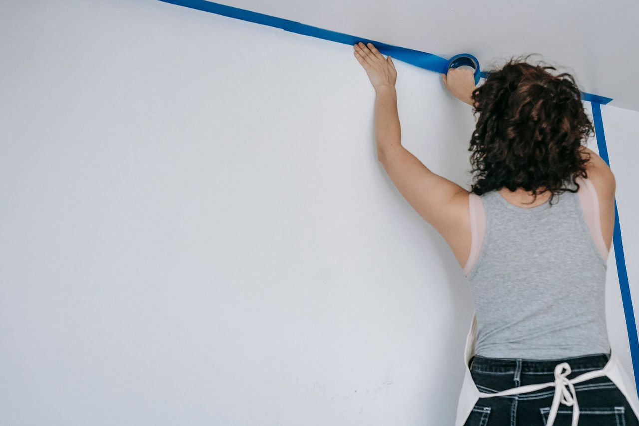 Abklebearbeiten mit Malerkrepp an einer hellen Wand