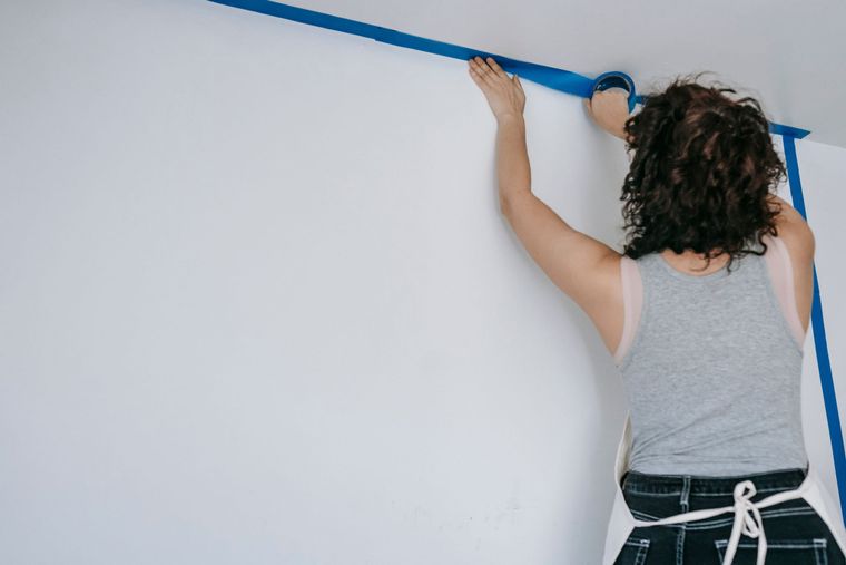 Abklebearbeiten mit Malerkrepp an einer hellen Wand.
