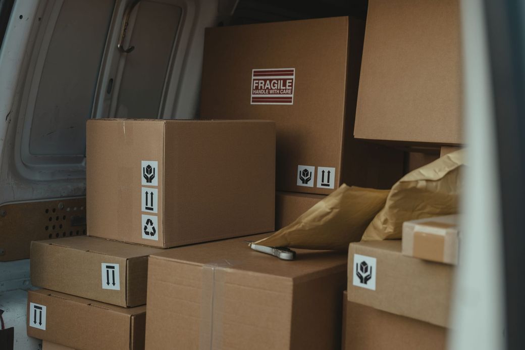 Gestapelte Umzugskartons im Laderaum eines Transporters.